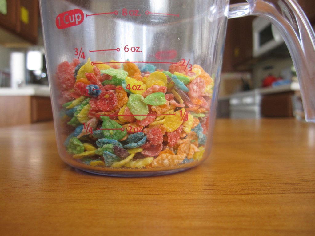 Photograph of Fruity Pebbles breakfast cereal in a 1-cup measuring cup.